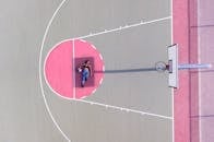 无人机在白天拍摄了室外球场上与篮球合影的运动员