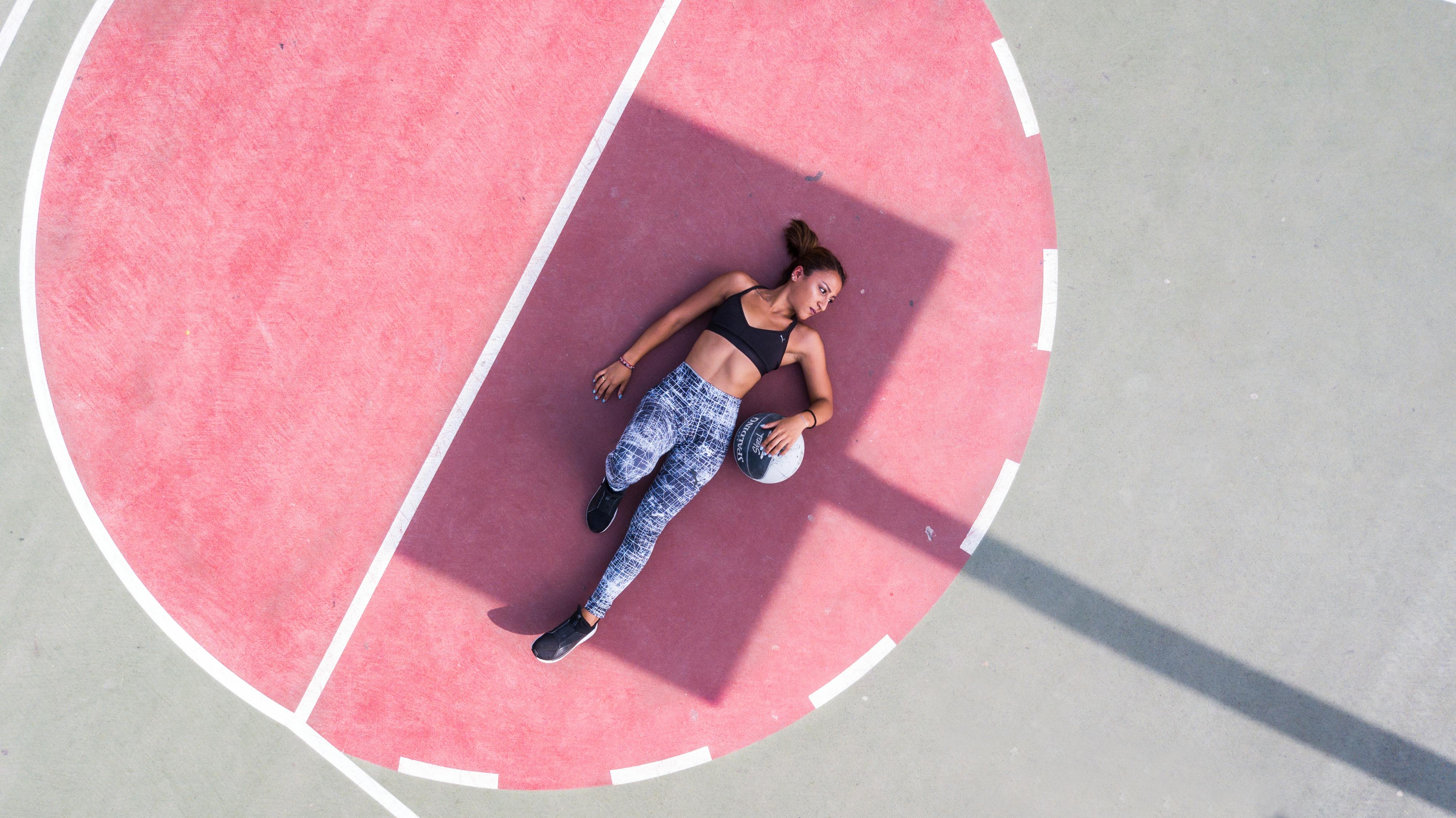 Woman Standing Near Basketball Hoop Controlling Drone · Free Stock Photo