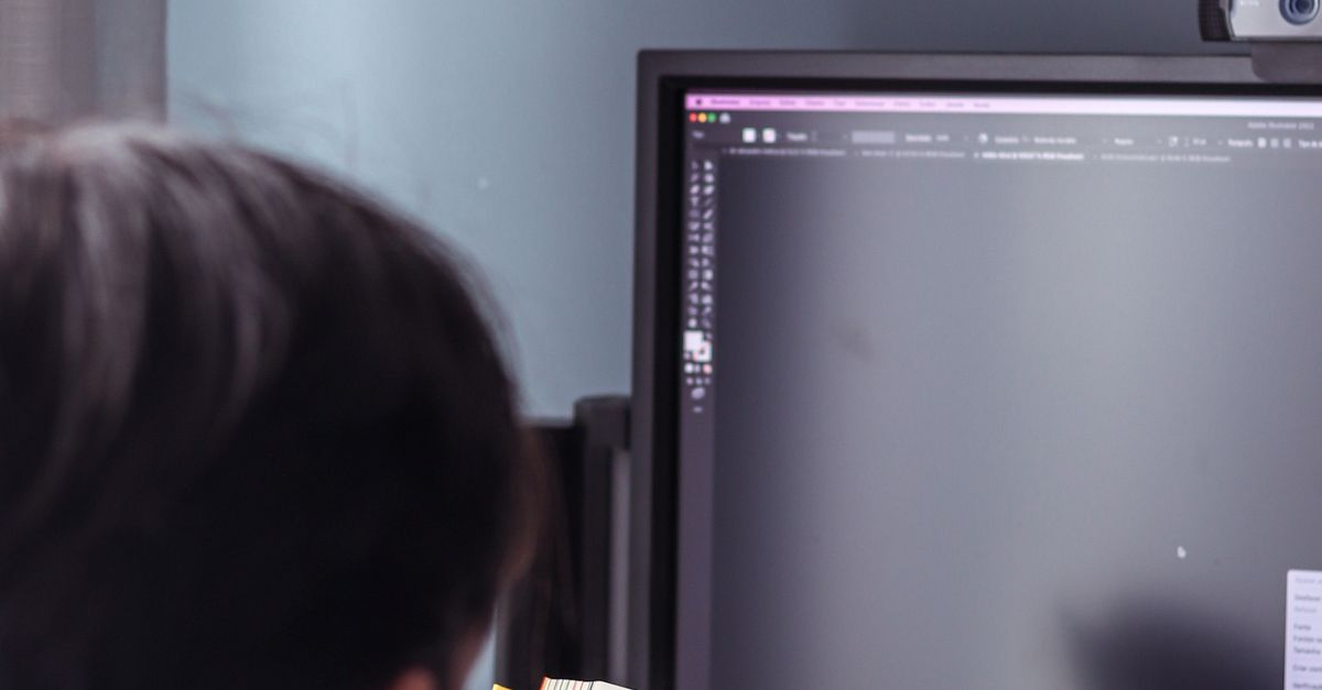 Person Reading From Computer Person in Front of Computer Monitor Reading Book · Free Stock Photo