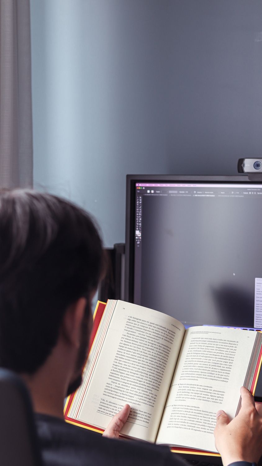 Computer Reading Person in Front of Computer Monitor Reading Book · Free Stock Photo