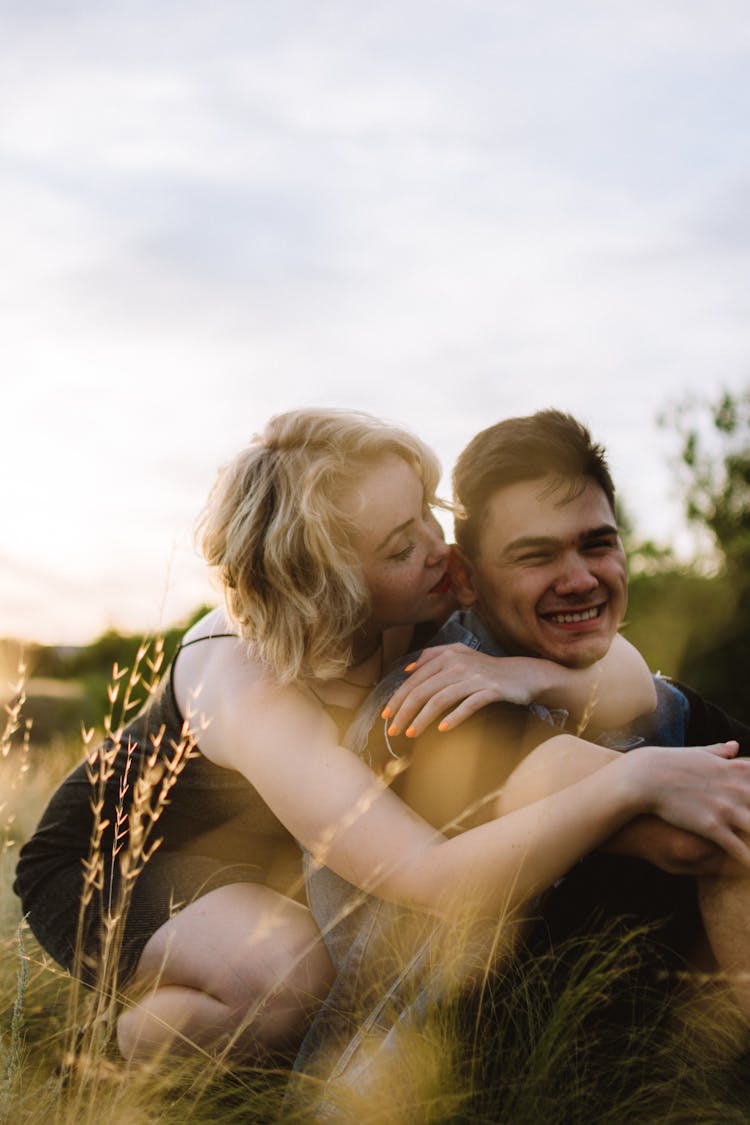 Blonde Girl Cuddling Boyfriend And Kissing