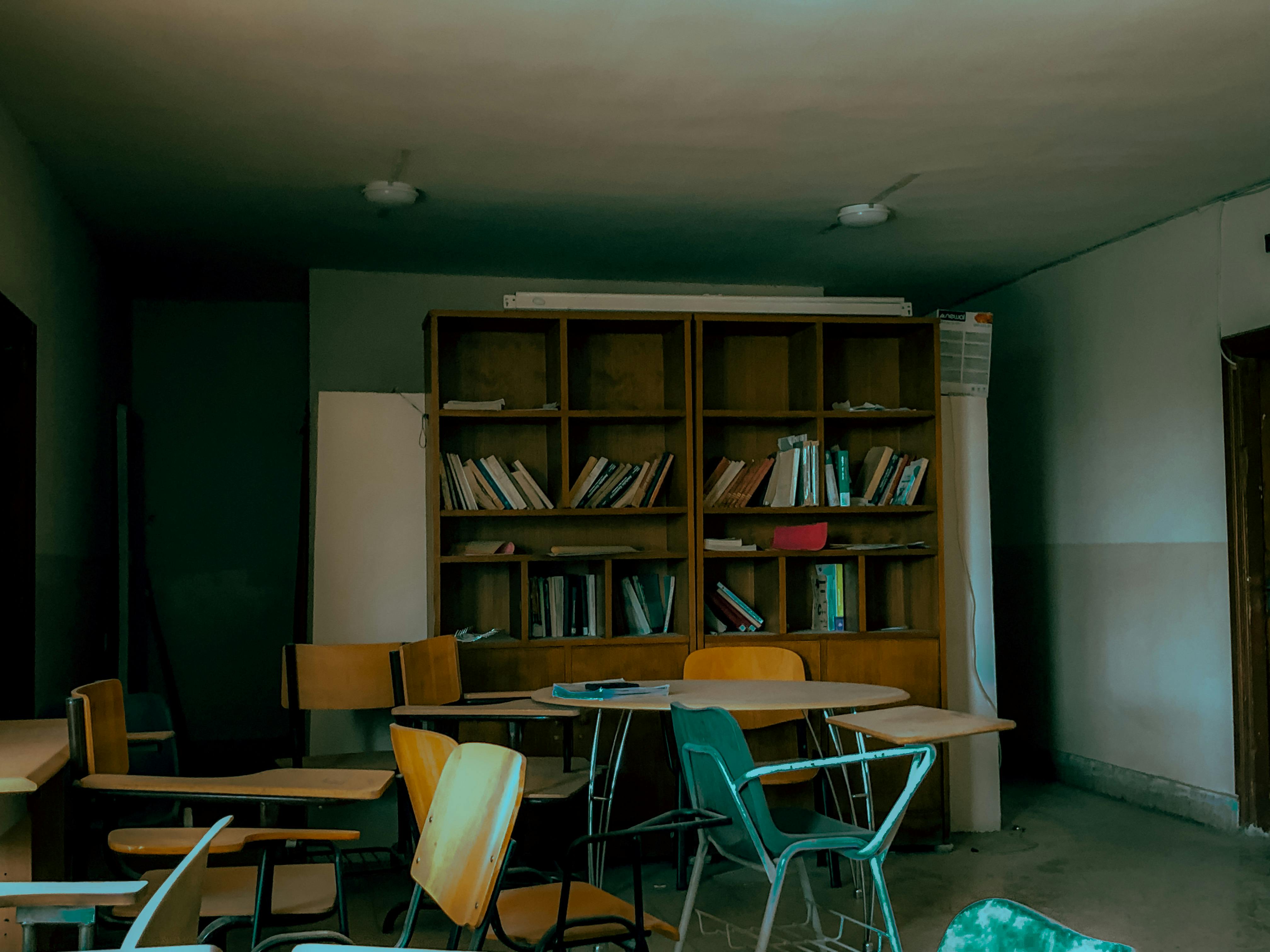 brown wooden book shelf near white chair