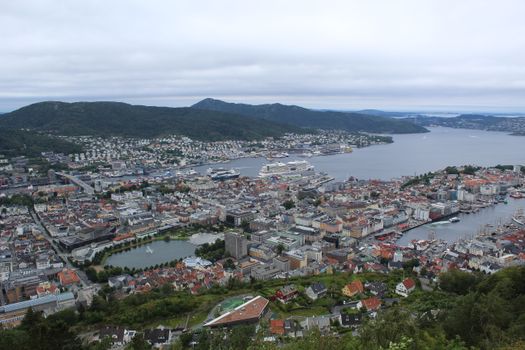 A breathtaking aerial view of Bergen's harbor, surrounded by mountains and sea.