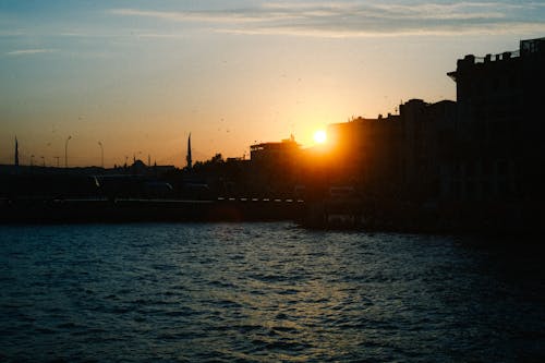 akşam karanlığı, binalar, deniz içeren Ücretsiz stok fotoğraf