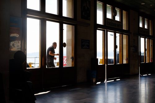 Free A silhouetted man stands against the bright backdrop in Üsküdar ferry terminal, Istanbul. Stock Photo