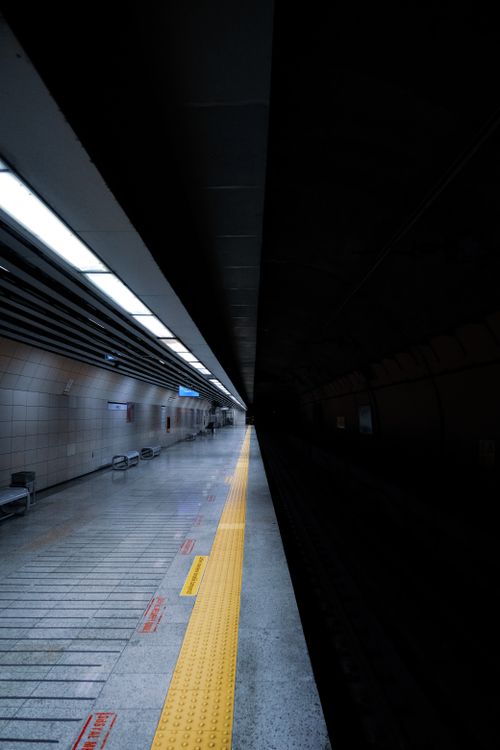 Free Empty underground train station platform with dark shadows creating an intriguing atmosphere. Stock Photo