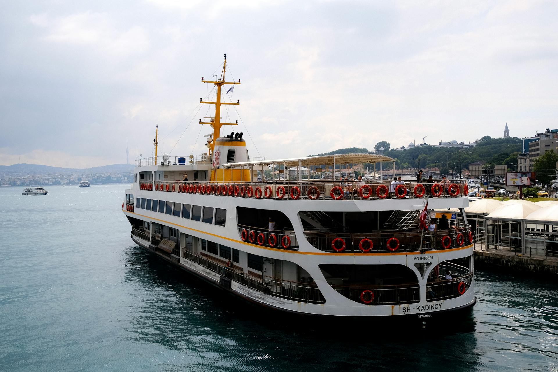 Passenger ferry at Istanbul harbor with city skyline in the background.