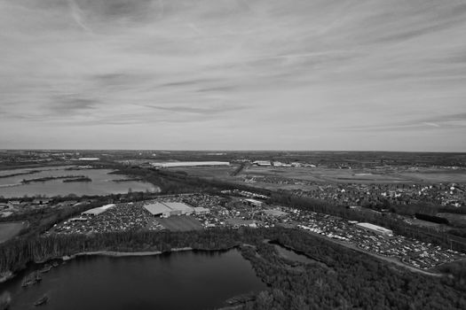 Black and white aerial photo of an industrial area with a lake in England, showcasing flat landscape.