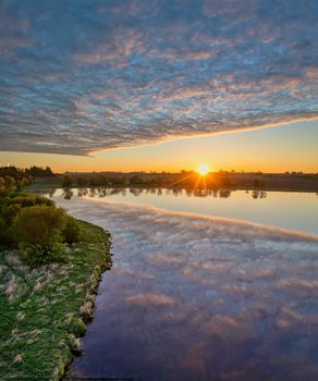 Beautiful sunrise over a tranquil lake in Minnesota, reflecting vibrant skies and calm waters.