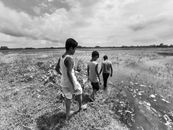 Grayscale Photo of 2 Men and 2 Women Walking on the Field