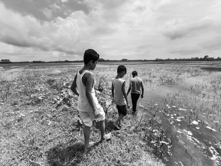 Boys Walking Barefooted On A Swamp