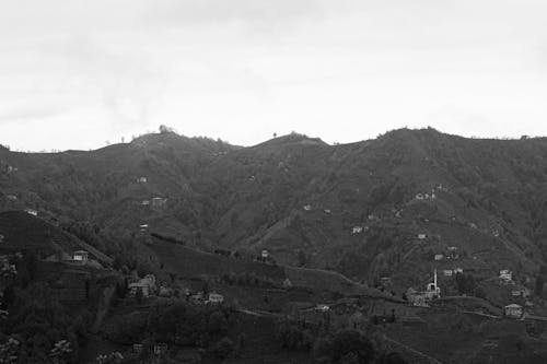A Grayscale of a Mountain with Houses