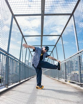 Man striking a dynamic pose on a city pedestrian bridge in stylish urban attire.