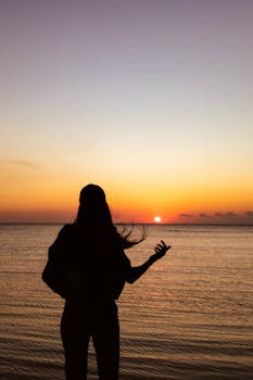 A captivating silhouette of a woman at Yalova beach during a vibrant sunset.