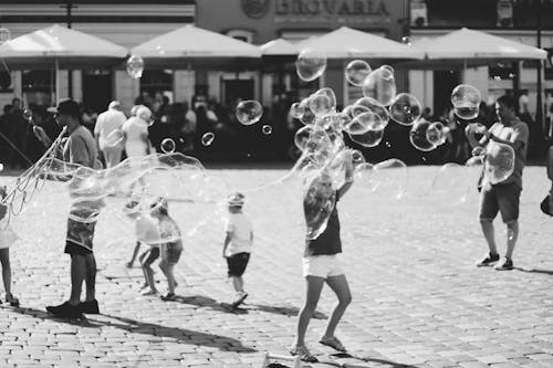 Grayscale Photography of Children Playing on Road