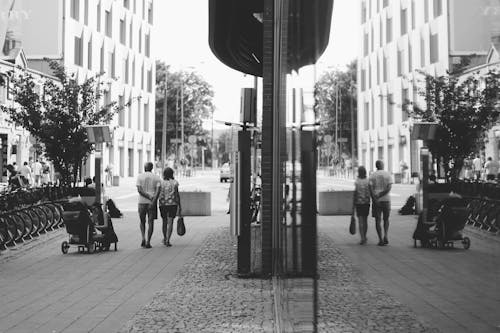 Grayscale Photography Of Man And Woman Walking At The Street