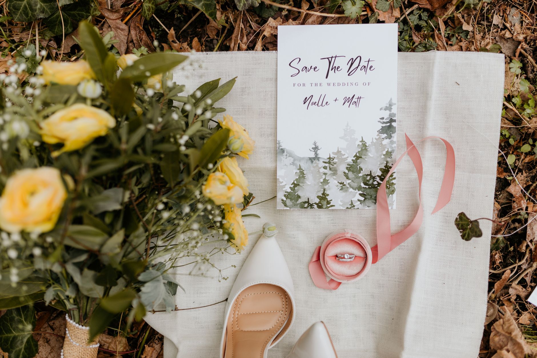 Flat lay of wedding invitation with yellow roses, rings, and shoes. Perfect for romantic wedding themes.