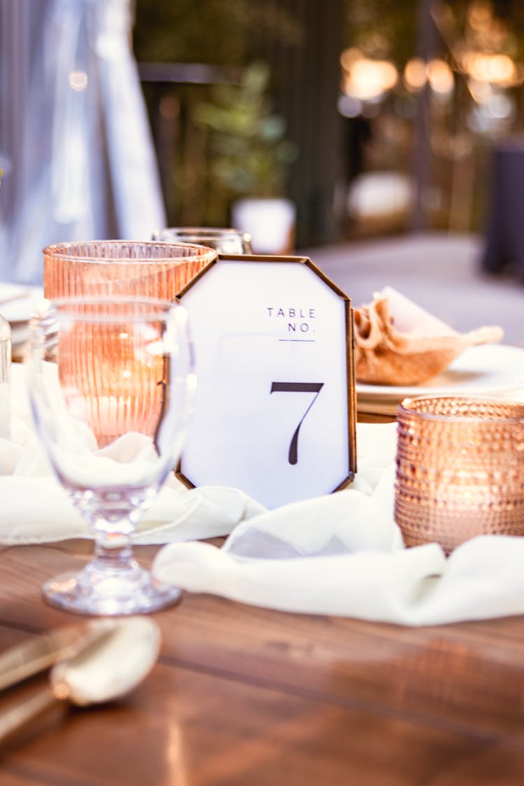 A Table Number Signage Near A Candle