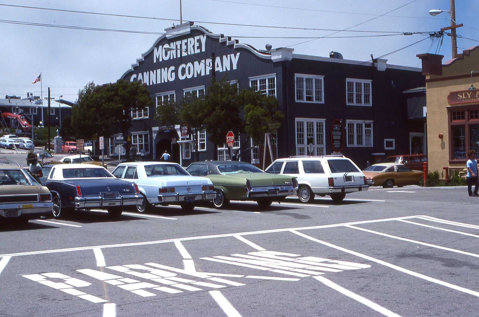 Classic cars parked at the historic Monterey Canning Company lot, capturing a vintage atmosphere.