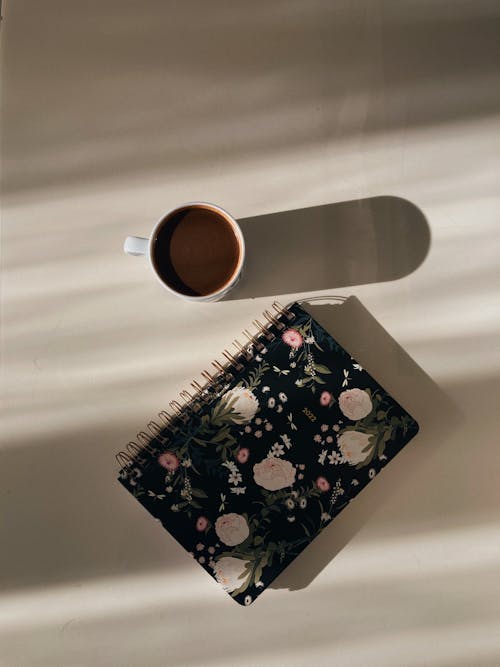 Overhead Shot of a Cup near a Planner