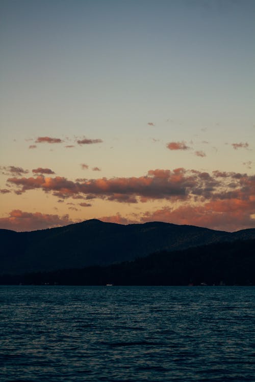 Free Silhouette of Mountain Near Body of Water during Sunset Stock Photo