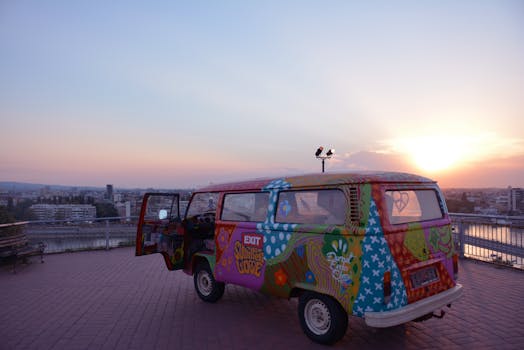 Vibrantly painted van with hippie motifs parked on a Novi Sad overlook during sunset, Serbia.