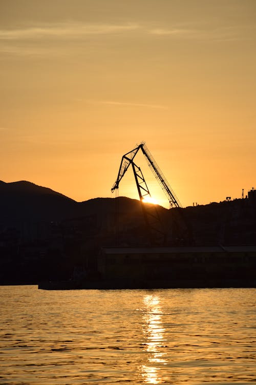 Foto d'estoc gratuïta de aigua, capvespre, grua de construcció