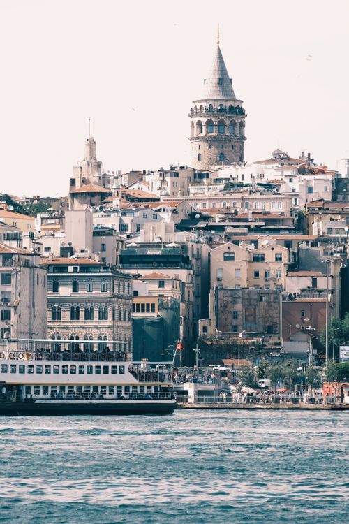 Free A scenic view of Istanbul's Galata Tower and surrounding historic buildings by the sea. Stock Photo