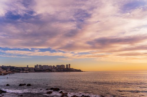 Free Breathtaking view of Viña del Mar coastline during a vibrant sunset with cityscape and tranquil ocean. Stock Photo