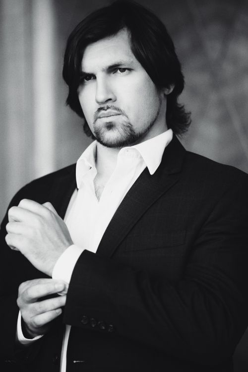 Free Elegant black and white portrait of a man adjusting his suit, embodying sophistication. Stock Photo