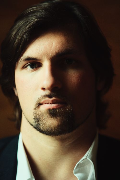 Free Close-up portrait of a young man with a serious expression, showcasing modern male fashion. Stock Photo