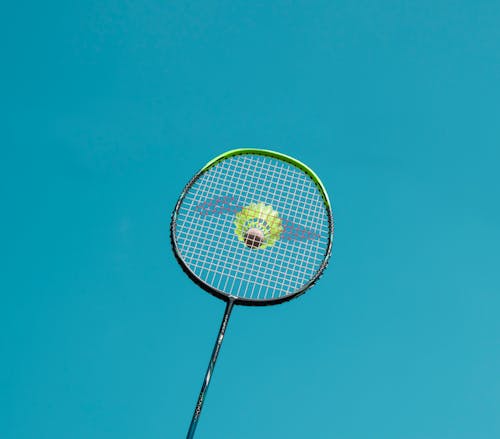 A Badminton Racket and Shuttlecock Under the Blue Sky