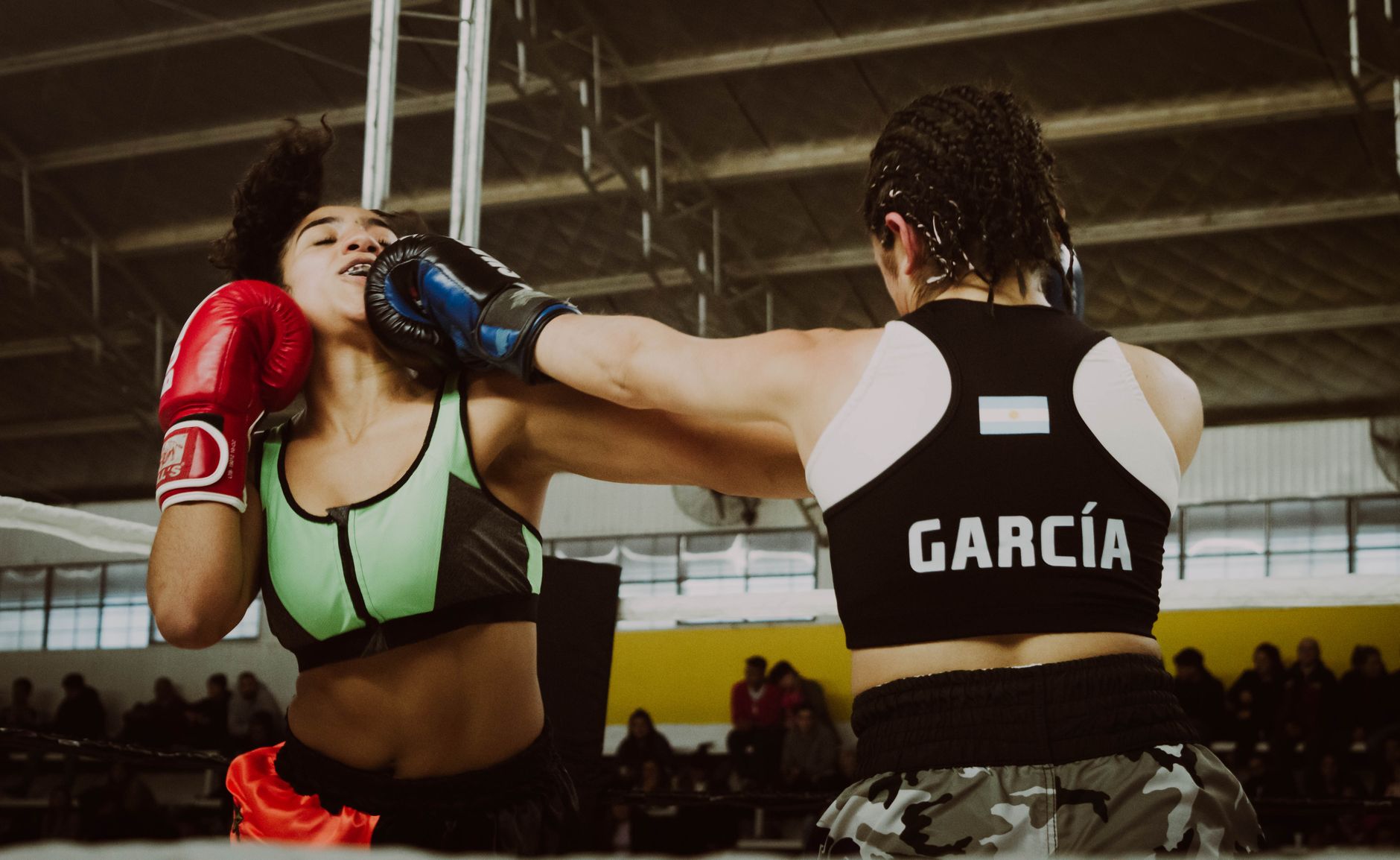Two female boxers engaged in a dynamic match, demonstrating strength and skill.