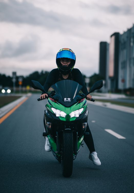 Person Rider A Person Riding on a Green Motorcycle Moving on the Road · Free Stock Photo