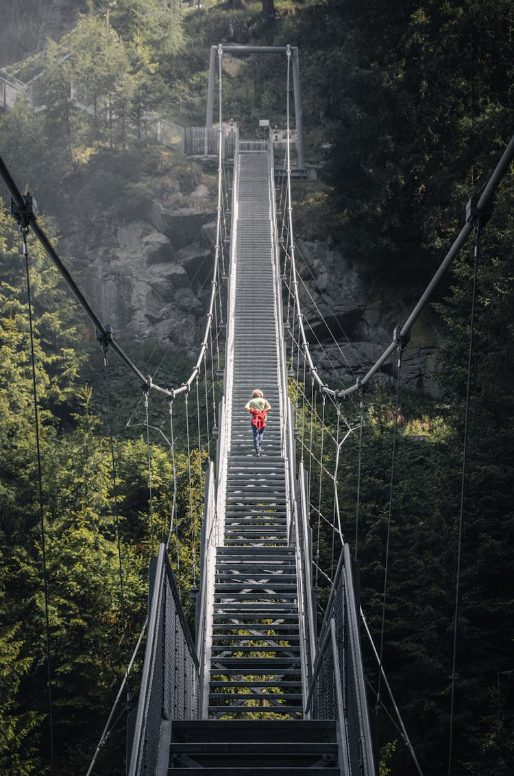 Woman Crossing A Hanging Bridge