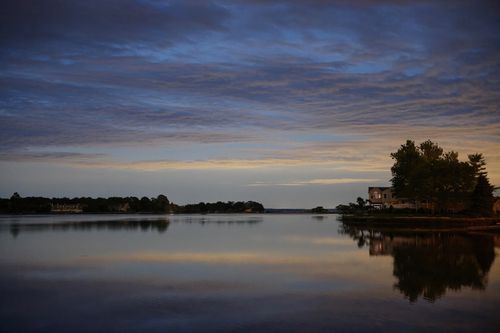 Free Peaceful lakeside scene at twilight in Stamford, CT, with calm waters and a cloudy sky. Stock Photo
