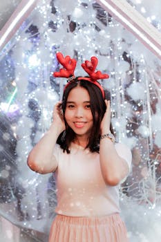 一位快乐的亚洲女性戴着驯鹿头带，在节日的冬季背景下开心地微笑着