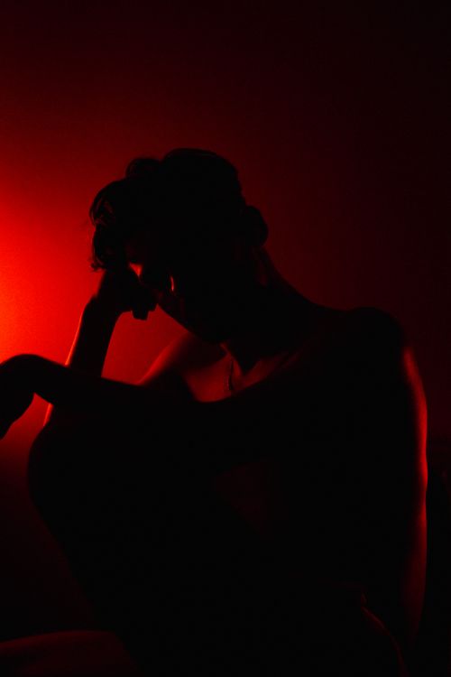 Free Artistic silhouette shot of a man against striking red light, creating a dramatic and moody atmosphere. Stock Photo
