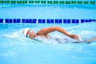 一名游泳运动员在干净的室外游泳池里精力充沛地游着自由泳，展现了竞争精神