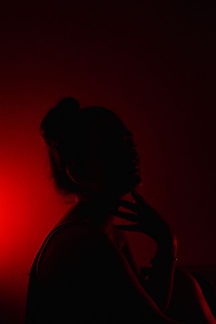 Silhouette portrait of a woman in dramatic red lighting, showcasing a mysterious mood.