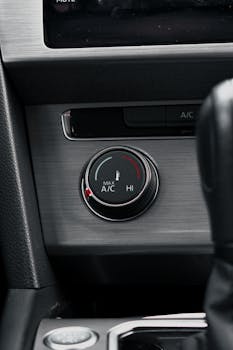 Detailed image of a car's air conditioning knob and dashboard controls.