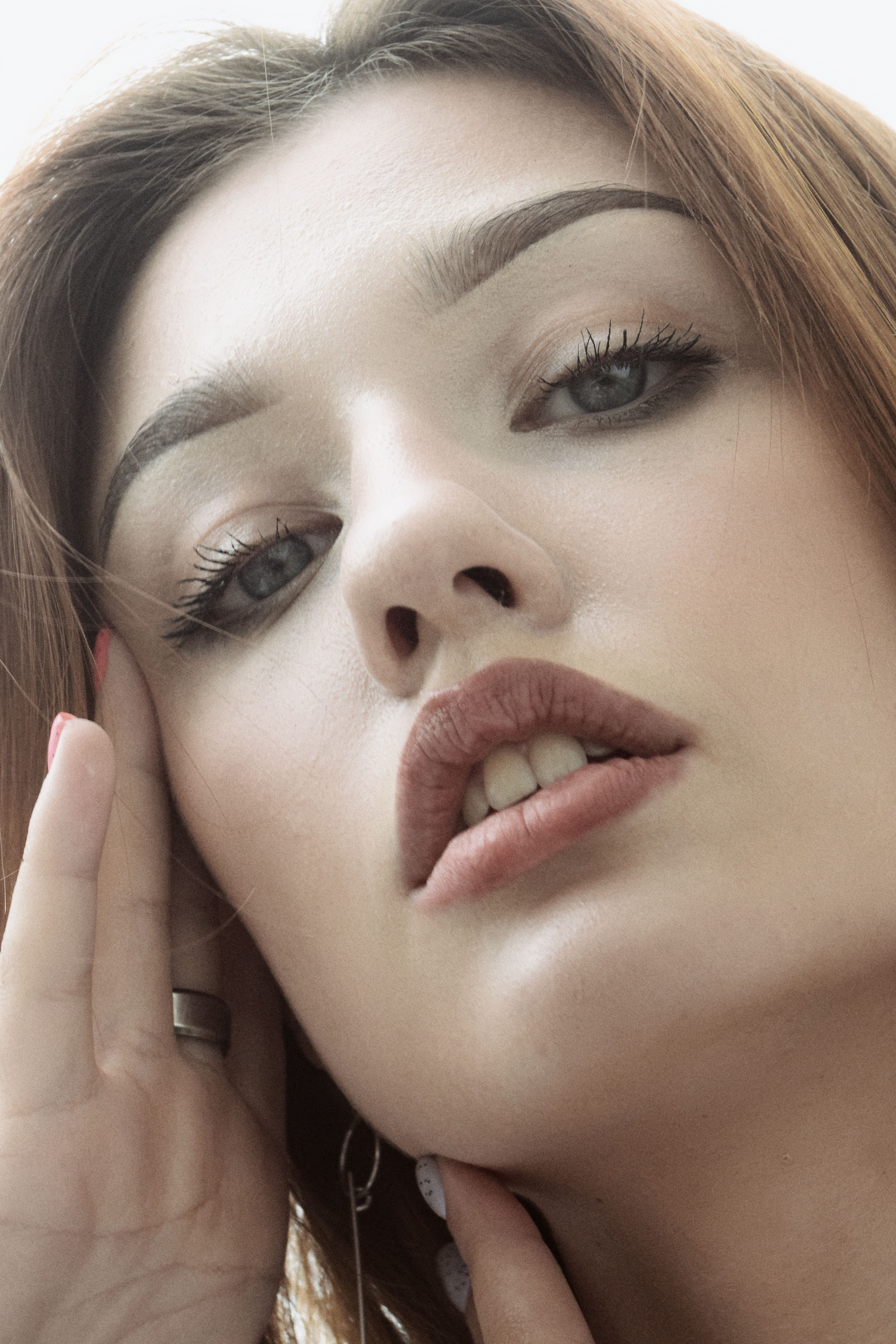 Intimate close-up portrait of a woman with light makeup, showcasing natural beauty and elegance.