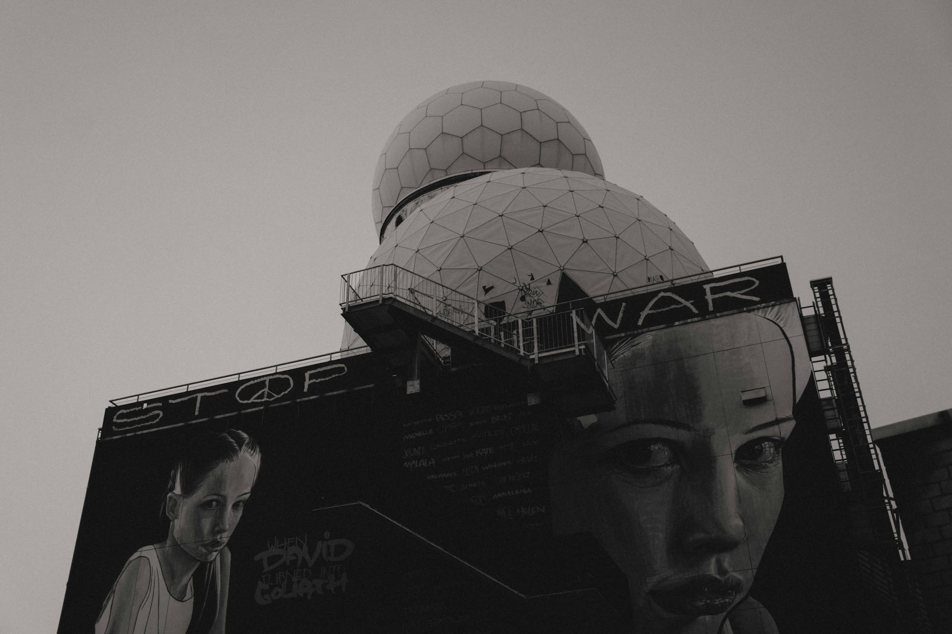 Black and White Photo of a Dome and Poster with Anti-War Script