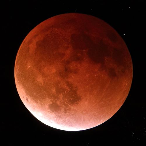 Free Close-up of a blood moon eclipse against a dark, starry sky showcasing the lunar surface. Stock Photo