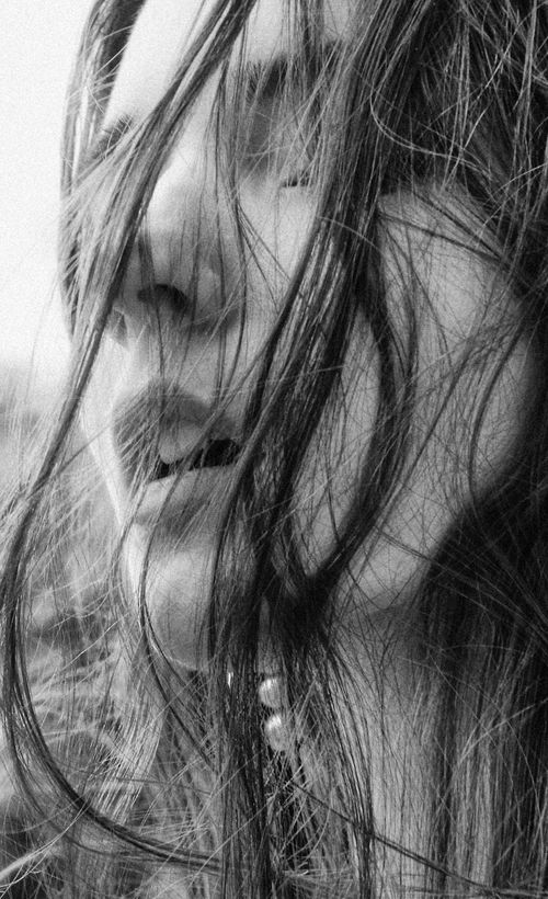 Free Captivating black and white portrait of a woman with messy hair, evoking emotion and mystery. Stock Photo