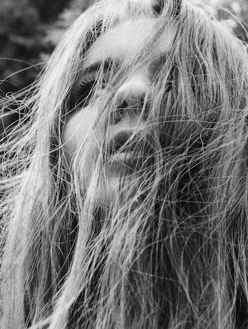 A Grayscale Photo of a Woman's Face Covered with Hair