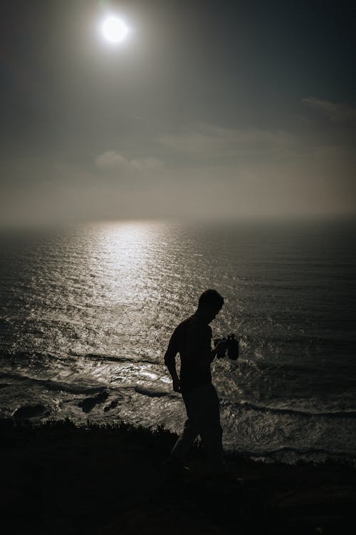 Silhouette of Man Walking on Seashore