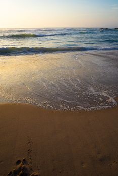 A peaceful sunset over a sandy beach with gentle waves lapping the shore. Perfect for relaxation.