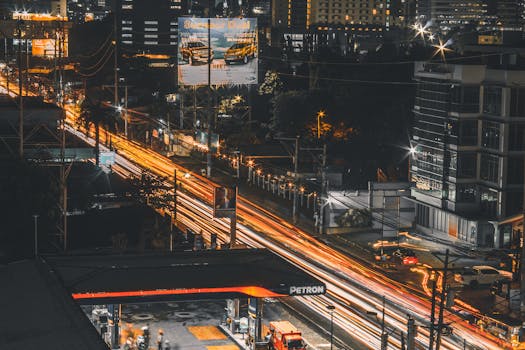 A dynamic long-exposure shot of Cebu City at night, highlighting the bustling urban life with illuminated streets and buildings.