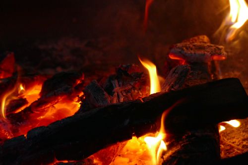Burning embers and firewood in a night campfire — photo by Nuh Isa El Carillo on Pexels